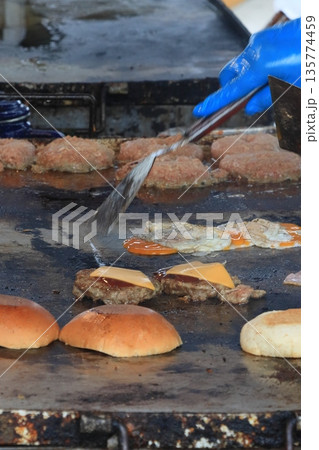 鉄板で焼き上げられるハンバーガー 135774459