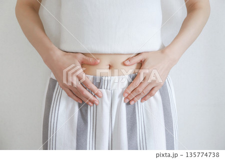 お腹を押さえる女性の腹部　ダイエット 135774738
