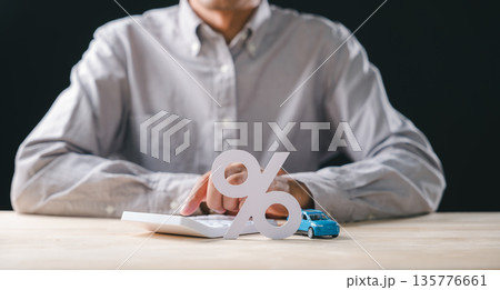 Person computes car interest rate using calculator, showing percentage icon beside blue toy auto, envisioning automobile loan payment and finance strategy Person computes car interest rate using calculator, showing percentage icon beside blue toy auto, envisioning automobile loan payment and finance strategy 135776661