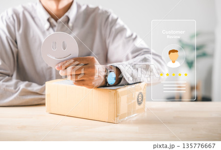 Customer shows positive satisfaction experience, giving happy face feedback while holding smile icon above delivery box, online shopping review concept illustrates excellent service Customer shows positive satisfaction experience, giving happy face feedback while holding smile icon above delivery box, online shopping review concept illustrates excellent service 135776667