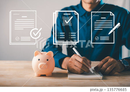 Saving in piggy bank for learning and education, college career growth helps man plan financial future while writing notes for professional development and future success Saving in piggy bank for learning and education, college career growth helps man plan financial future while writing notes for professional development and future success 135776685