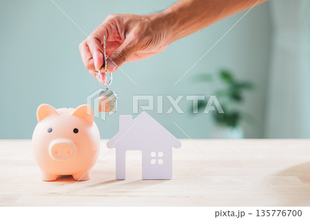 Secure cyber bank piggy security saving, Privacy fundamental, hand holds home keys near house model on table, signifying property dreams and future investment success for family Secure cyber bank piggy security saving, Privacy fundamental, hand holds home keys near house model on table, signifying property dreams and future investment success for family 135776700