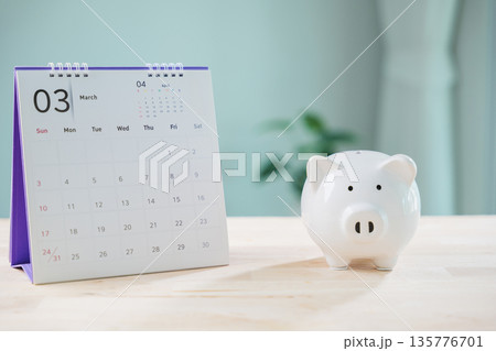 monthly saving money save plan march calendar piggy bank financial manage retirement insurance date and tax growth goals on wooden table in bright home office room background 135776701