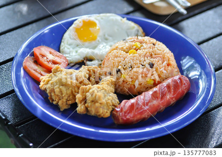 stir fried rice or fried rice with sunny side up egg , fried chicken and sausage 135777083