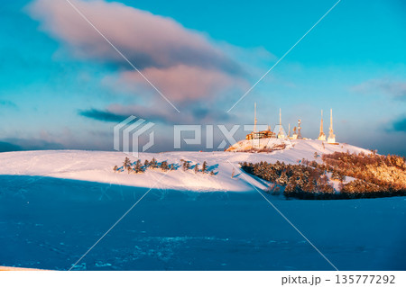 冬の晴れた日の高原と電波塔の要塞 135777292