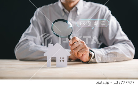 Man performs real estate appraisal inspecting house home property using magnifying glass, searching details for accurate valuation, offering inspector contact for thorough property inspection service 135777477