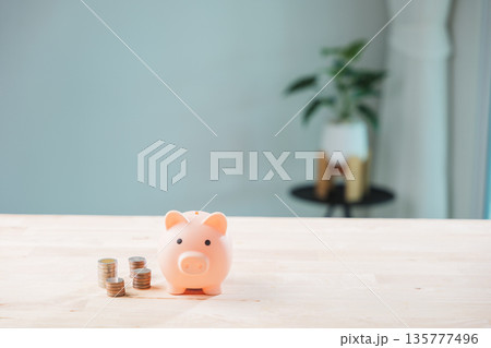 Global economy money bank piggy finance stock growth business concept shows pink bank beside coin stacks on wooden table as people look to save and invest for true economic success Global economy money bank piggy finance stock growth business concept shows pink bank beside coin stacks on wooden table as people look to save and invest for true economic success 135777496