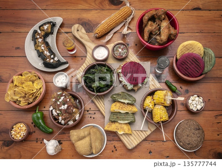 mixed colombian and venezuelan food meal spread on wooden restaurant table mixed colombian and venezuelan food meal spread on wooden restaurant table 135777744