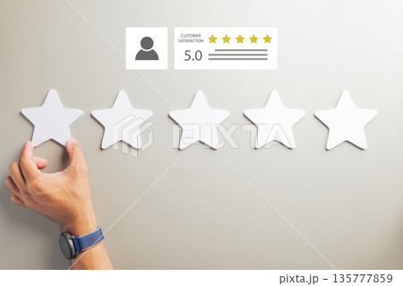 Hand places five star review, demonstrating excellent customer feedback and online satisfaction for business service, promoting positive survey experience with top rating five stars 135777859