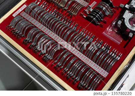 Concave sphere in ophthalmologist kit. Case with lenses of all diopters for glasses selection. Ophthalmologist tools. Stigmatic diopters are arranged in row in order. Vision testing with lenses Concave sphere in ophthalmologist kit. Case with lenses of all diopters for glasses selection. Ophthalmologist tools. Stigmatic diopters are arranged in row in order. Vision testing with lenses 135780220