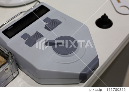 Testing equipment on ophthalmologist desk. Vision testing with device. Concept of modern technologies in medicine. Eyes testing and glasses selection with device. Ophthalmologist tool 135780223