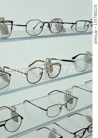 Selection of prescription glasses on glass shelves of optical store with frames in variety of designs for any customer taste. Vertical concept photo about choosing and buying prescription glasses Selection of prescription glasses on glass shelves of optical store with frames in variety of designs for any customer taste. Vertical concept photo about choosing and buying prescription glasses 135780228