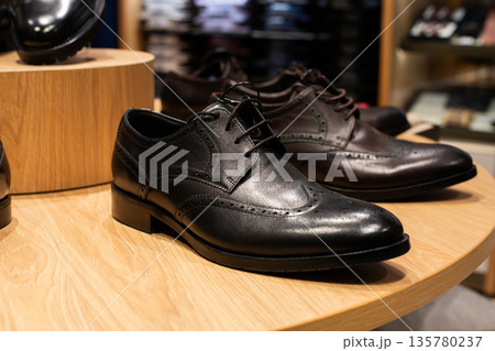 Shelf of high quality leather shoes for men. Premium store of classic clothing and footwear. Selection of black shoes for suit. Classic look for business. Choosing businessman outfit 135780237