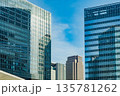 青空と日差しを反射するガラスのオフィスビル群のクローズアップ 135781262
