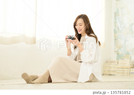 フィルムカメラを手に持つ女性 135781852