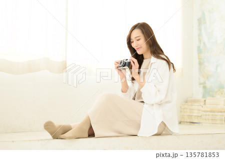 フィルムカメラを手に持つ女性 135781853