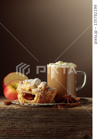 Vienna strudel and caffe latte on an old wooden table. 135782199
