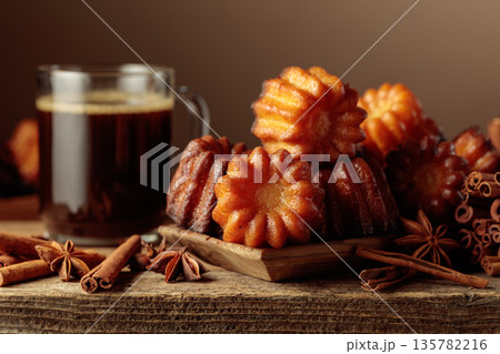 Cinnamon cakes and black coffee on an old wooden table. Cinnamon cakes and black coffee on an old wooden table. 135782216