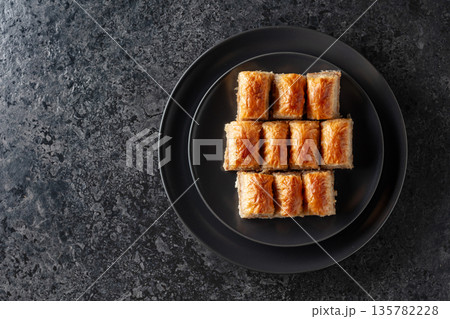 Baklava with walnuts on a blackstone table. Baklava with walnuts on a blackstone table. 135782228