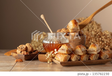 Baklava with walnuts and honey on a beige background. 135782230