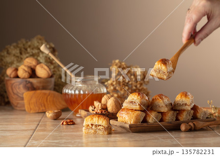 Baklava with walnuts and honey on a beige background. 135782231