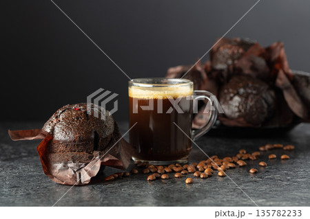Dark chocolate muffins and cup of black coffee. Dark chocolate muffins and cup of black coffee. 135782233