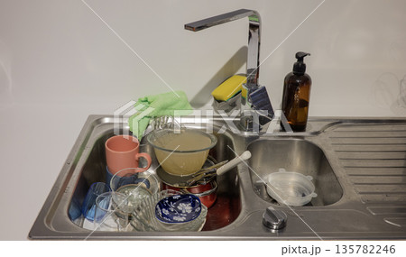 Dirty dishes in sink on the kitchen 135782246