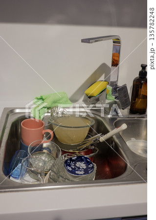 Dirty dishes in sink on the kitchen Dirty dishes in sink on the kitchen 135782248