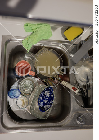Dirty dishes in sink on the kitchen Dirty dishes in sink on the kitchen 135782253
