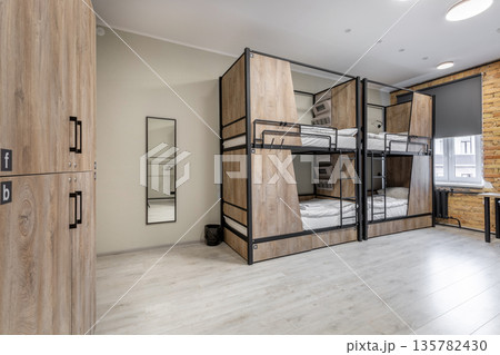 Spacious hostel dormitory with private wood-paneled bunk beds Spacious hostel dormitory with private wood-paneled bunk beds 135782430
