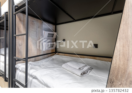 Modern hostel bunk bed interior with white linen and organizer Modern hostel bunk bed interior with white linen and organizer 135782432