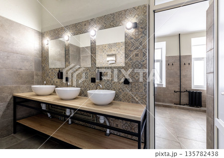Modern hostel bathroom with vessel sinks and industrial loft design Modern hostel bathroom with vessel sinks and industrial loft design 135782438