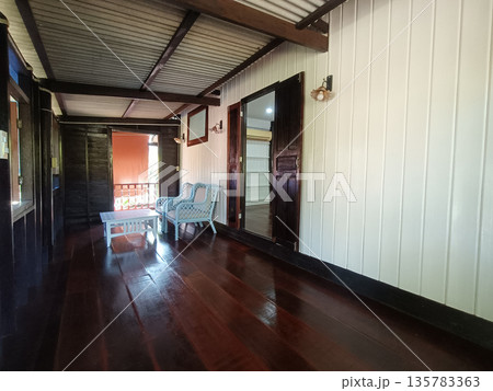 Wooden porch, rustic cabin, veranda, wicker chair, coffee table, wooden floor, exterior corridor with warm light Wooden porch, rustic cabin, veranda, wicker chair, coffee table, wooden floor, exterior corridor with warm light 135783363