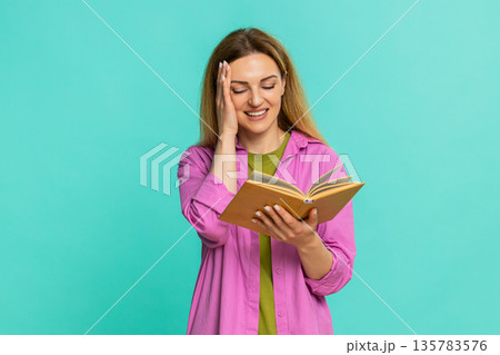 Woman reading book with focused expression flipping pages calmly showing interest and concentration 135783576