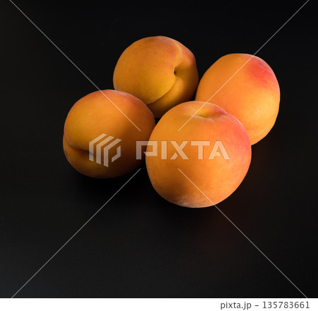 Four ripe fruits of Apricot, on a black background, isolated 135783661