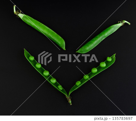Two whole peas and one open stitch of peas with grains on a black background Two whole peas and one open stitch of peas with grains on a black background 135783697