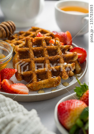 Belgian waffles with strawberries, cup of tea and fresh fruits. Homemade breakfast food Belgian waffles with strawberries, cup of tea and fresh fruits. Homemade breakfast food 135783893