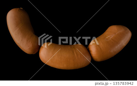 Three boiled sirloin sausages on a black background isolated Three boiled sirloin sausages on a black background isolated 135783942