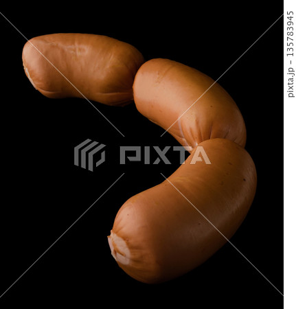 Three boiled sirloin sausages on a black background isolated Three boiled sirloin sausages on a black background isolated 135783945