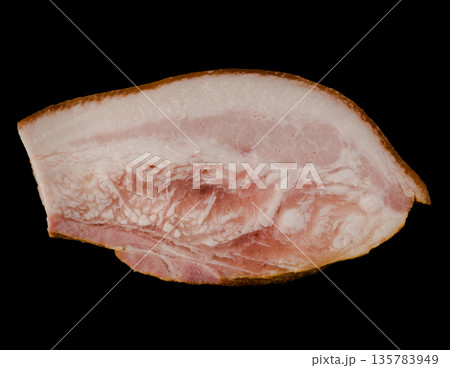 A thick piece of ready-made appetizing, smoked, lard with layers of meat on a black background in isolation 135783949