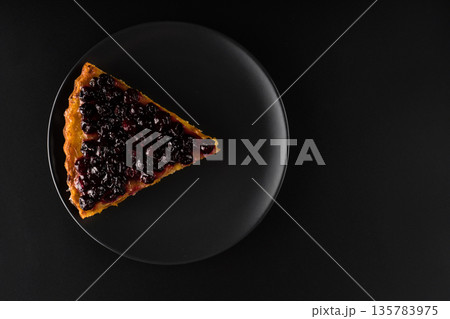 Piece of pie with carrots and currants sprinkled on top on black background f isolation Piece of pie with carrots and currants sprinkled on top on black background f isolation 135783975