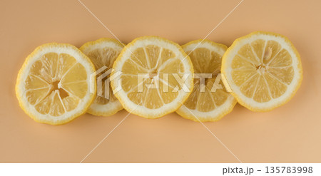 Pieces of lemon, Lemon sliced into slices on a background of apricot color in isolation 135783998