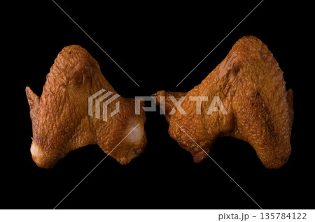 Smoked appetizing chicken legs, chicken lids, on a black background in isolation, poultry meat, chicken smoked meat Smoked appetizing chicken legs, chicken lids, on a black background in isolation, poultry meat, chicken smoked meat 135784122