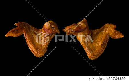 Smoked appetizing chicken legs, chicken lids, on a black background in isolation, poultry meat, chicken smoked meat Smoked appetizing chicken legs, chicken lids, on a black background in isolation, poultry meat, chicken smoked meat 135784123