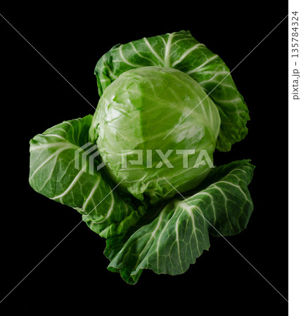 Head of green young fresh cabbage with loose leaves, on black background Head of green young fresh cabbage with loose leaves, on black background 135784324