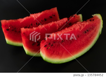 Three skibki ripe watermelon on a black background Three skibki ripe watermelon on a black background 135784452