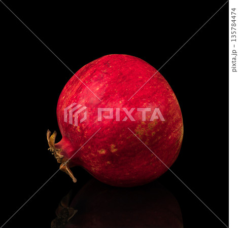 ripe whole pomegranate, on a black background isolated, with reflection ripe whole pomegranate, on a black background isolated, with reflection 135784474
