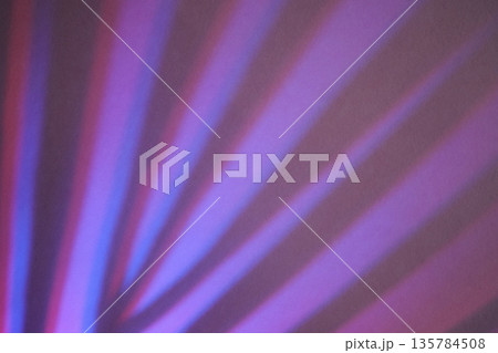 Radial purple and blue light rays creating an abstract pattern on textured surface 135784508
