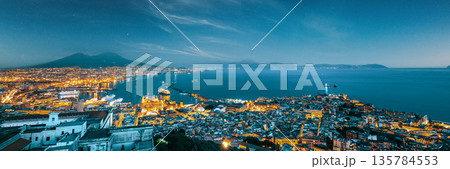 Naples, Italy. Skyline Cityscape In Evening Lighting. Tyrrhenian Sea And Landscape With Volcano Mount Vesuvius. City In Night Illuminations 135784553