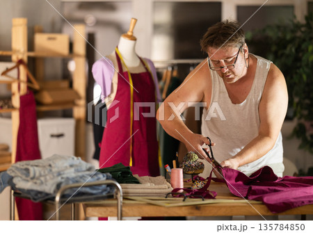 Man seamstress work with scissors and cutting Man seamstress work with scissors and cutting 135784850